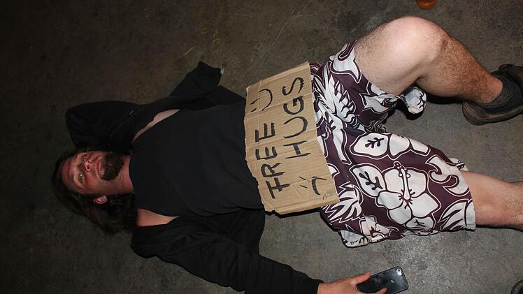 Auch wenn er nicht so aussieht, so bietet dieser junge Mann doch eine Gefälligkeit an: kostenlose Umarmungen - free hugs.