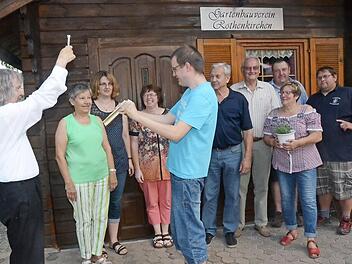 Pater Helmut Haagen (l.) segnet das renovierte und um Außenanlagen erweiterte Vereinsheim des Gartenbauvereins Rothenkirchen. Mit im Bild eine überglückliche Vorsitzende Gudrun Müller (2. v. r.) Foto: K.- H. Hofmann