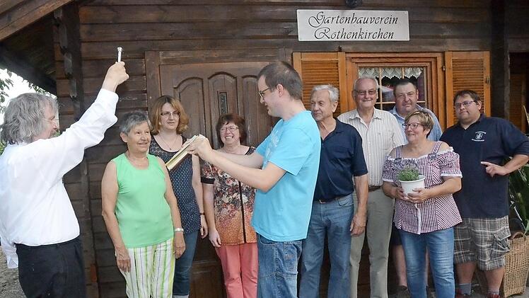Pater Helmut Haagen (l.) segnet das renovierte und um Außenanlagen erweiterte Vereinsheim des Gartenbauvereins Rothenkirchen. Mit im Bild eine überglückliche Vorsitzende Gudrun Müller (2. v. r.) Foto: K.- H. Hofmann