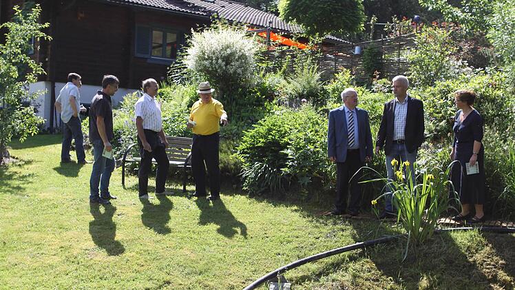 Jürgen Schmitt (Zweiter von links) und seine Frau Damaris (rechts) erklären den ehrengästen ihre Gartenanlage. Foto: Michael Wunder
