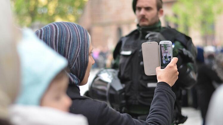 Muslima filmt Predigt. Foto: Nikolas Pelke