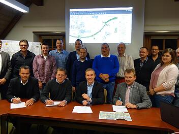 Unterzeichnung der Petition (von links): vorne: Georg Hemmerlein, Matthias Rothe, Bernd Höfer und Ludwig Weiß unterschreiben die Stellungnahme der Gemeinde Meeder im Beisein (dahinter stehend) von Gemeinderäten und weiteren Gästen. Foto: Lothar Weidner