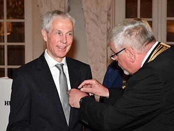 Oberbürgermeister Norbert Tessmer (links) heftet dem scheidenden Sprecher der HUK-Vorstände, Wolfgang Weiler, die Bürgermedaille an. Foto: Ronald Rinklef