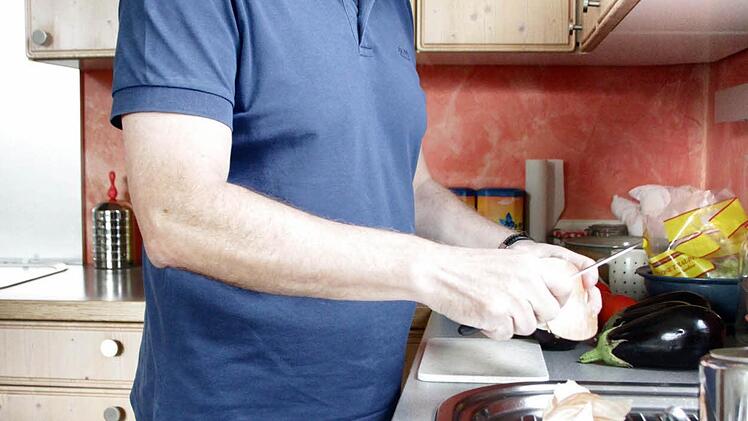 Karl Waldmann beim Häuten einer Zwiebel.