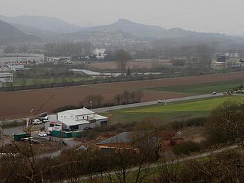 Blick vom Schönberg hinunter auf das Gewerbegebiet "Lohwiese", das bisher am Gebäude im Vordergrund endet. Nun wird es in Richtung hellgrüner Ackerfläche (rechts) erweitert. Die Erschließungsstraße verläuft parallel zur Bundesstraße 26 - bisher und auch weiterhin.  Foto: Günther Geiling