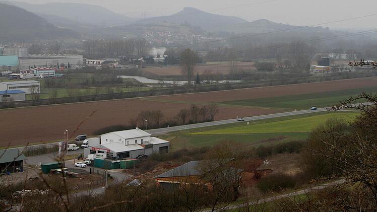 Blick vom Schönberg hinunter auf das Gewerbegebiet "Lohwiese", das bisher am Gebäude im Vordergrund endet. Nun wird es in Richtung hellgrüner Ackerfläche (rechts) erweitert. Die Erschließungsstraße verläuft parallel zur Bundesstraße 26 - bisher und auch weiterhin.  Foto: Günther Geiling