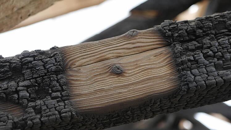 Wie dick der Ruß sich auf dem Holz abgesetzt hatte, lässt sich hier gut erkennen: Die helle Stelle ist schon gereinigt. Foto: M. Hoch