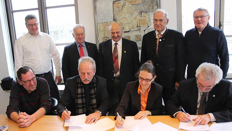 Viele glückliche Gesichter beim Unterschreiben des Kaufvertrags