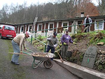 Für das Totengedenken richteten Hans Ködel, Helmuth Obermaier und Harald Eckert auch die Gedenktafeln wieder her. Stellvertretender Vorsitzende Gerhard Ködel freute sich auf die Überraschung. Denn erst vor wenigen Stunden hatte er erfahren, dass das Waldfreundeheim wieder genutzt werden kann. Foto: Sonja Adam