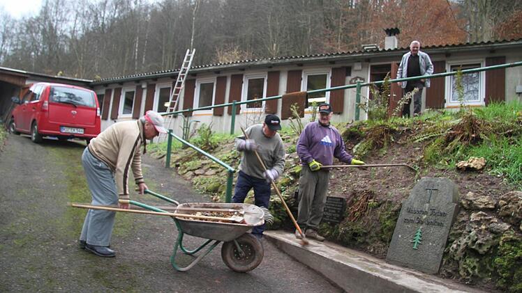 Für das Totengedenken richteten Hans Ködel, Helmuth Obermaier und Harald Eckert auch die Gedenktafeln wieder her. Stellvertretender Vorsitzende Gerhard Ködel freute sich auf die Überraschung. Denn erst vor wenigen Stunden hatte er erfahren, dass das Waldfreundeheim wieder genutzt werden kann. Foto: Sonja Adam