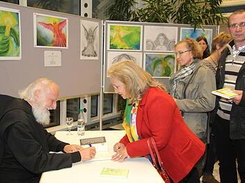 Nach dem Vortrag nutzten viele Fans die Gelegenheit, um sich Engelbilder oder Bücher von Pater Anselm Grün signieren zu lassen. Foto: Sonny Adam