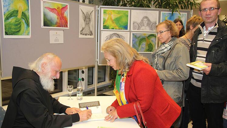 Nach dem Vortrag nutzten viele Fans die Gelegenheit, um sich Engelbilder oder Bücher von Pater Anselm Grün signieren zu lassen. Foto: Sonny Adam