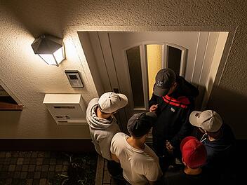 Nacht Wohnstra&szlig;e Vogelperspektive Haust&uuml;r Klingelstreich Gegensprechanlage M&auml;nner Gruppe Jugendliche BaseballKappe Draufsicht Stra&szlig;enbeleuchtung Gehweg Eingang Wohnhaus Bamberg Deutschland Streich unbekannte T&auml;ter Polizei Dunkelheit Laternen geparkte Autos Hauseingang anonym nicht identifizierbar Nachtszene Wohngebiet Sicherheit &Uuml;berwachung Perspektive