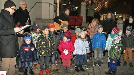 Die Kinder aus dem städtischen Kindergarten, Pfarrer Stephan Eschenbacher und Bürgermeister Günther Werner (von links) gestalteten den ersten Tag des begehbaren Adventskalenders in Haßfurt.  Fotos: sw