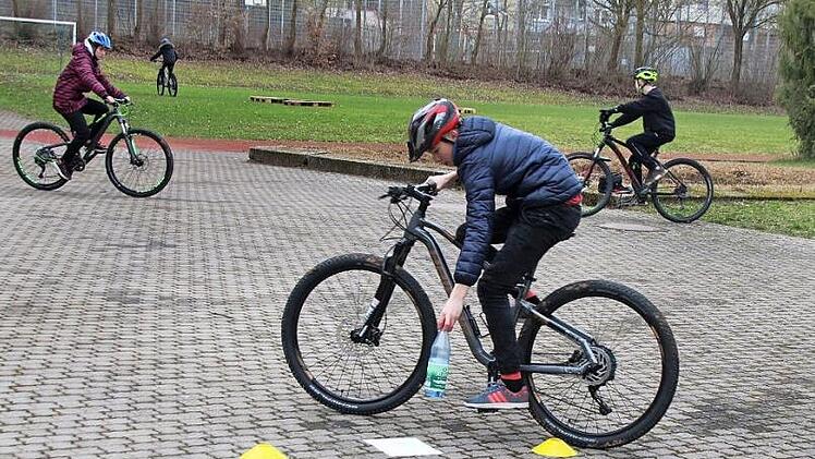 Geschicklichkeitsparcours: Im Fahren müssen die Kinder eine Flasche aufheben, eine Runde fahren und sie dann wieder am gleichen Ort abstellen. Foto: Thomas Malz