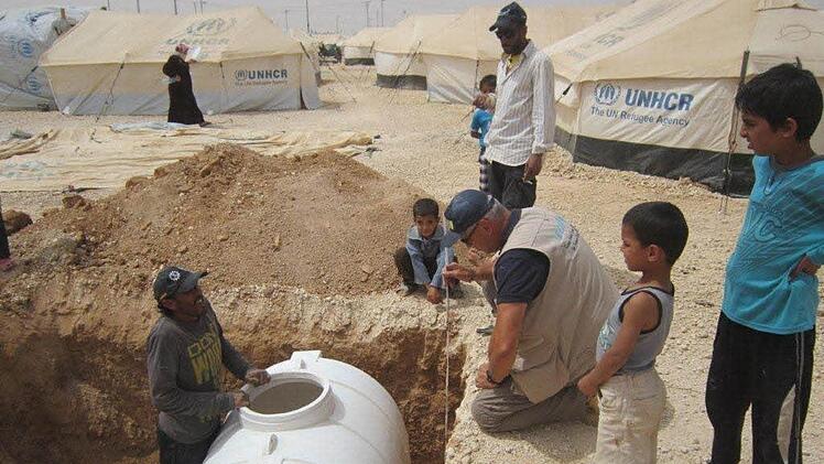 In Jordanien kümmerte sich Michael Gessner um die Wasserversorgung im Lager. Bewohner beobachten die Arbeiten.  Fotos: privat