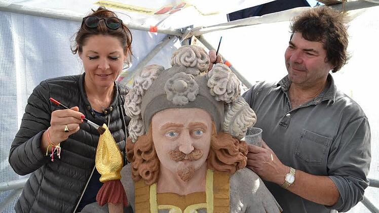 Die Restauratoren Iris von Künßberg-Schmidt und Uwe Franke legen letzte Hand an den Zinsfelder Brunnen. Hier wird überschüssiges Blattgold abgenommen. Foto: Uschi Prawitz