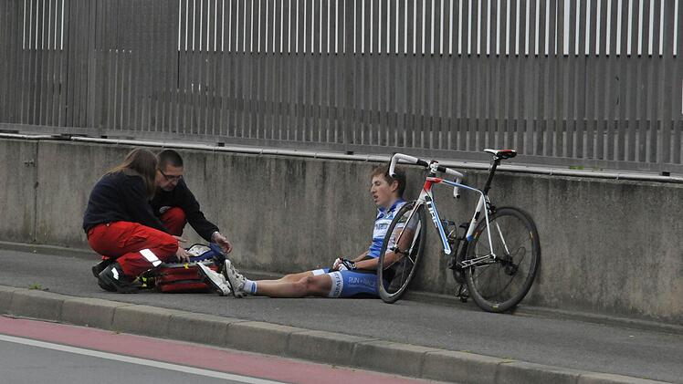 Schon nach wenigen Runden des Hauptrennens gab es einen Massensturz, der fünf Fahrer zum Aufgeben zwang. Hier wird Matthias Peter aus Passau medizinischversorgt