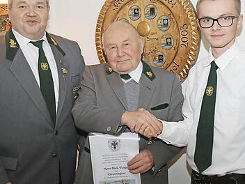 Oberschützenmeister Dennis Stang (links) und Schützenmeister Udo Stricker ernennen Hans Weigelt (Mitte) zum Ehrenmitglied.  Foto: Michael Stelzner
