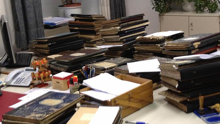 Im Amtszimmer von Standesbeamtin Simone Schöpplein stapeln sich die alten Personenstandsbücher der beiden neuen Gemeinden Rauhenebrach und Oberaurach. Foto: Günther Geiling