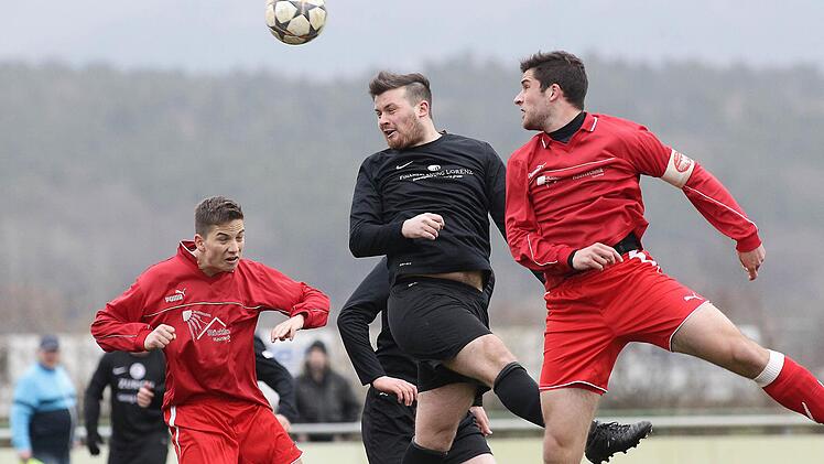 Thorsten Niemann (Mitte) kommt wie die Teuchatzer Fabian Stöcklein (l.) und Michael Haas nicht an den Flankenball.