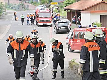 Überall Feuerwehr auf der Dorfstraße in Bischwind, als die Schlauchleitung vom Dorfbach zum Brandobjekt gelegt wird. Foto: Helmut Will