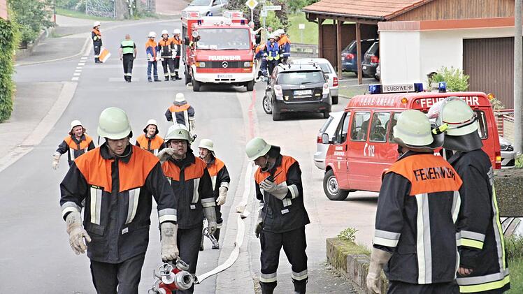 Überall Feuerwehr auf der Dorfstraße in Bischwind, als die Schlauchleitung vom Dorfbach zum Brandobjekt gelegt wird. Foto: Helmut Will