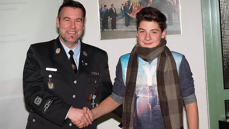 Kommandant Rainer Wanitschka begrüßte Benjamin Schmitt als neues Nachwuchs-Mitglied per Handschlag in der Feuerwehr Oberthulba. Foto: Gerd Schaar