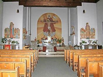 Betritt man das auf der Straße nach Hubertushöhe gelegene Gotteshaus, dann fällt einem vor allem das große Bild im Altarraum ins Auge. Es zeigt die Heilige Dreifaltigkeit: Gott hält den gekreuzigten Sohn und der Geist ist in Form einer Taube sichtbar. Foto: Hans Franz