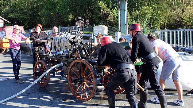 Viel Muskelkraft war nötig, um das Feuer zu löschen. Den historischen Einsatz demonstrierten die Brandschützer mit ihrer noch funktionstüchtigen Handdruckspritze von 1901. Foto: Feuerwehr/Maria Müller