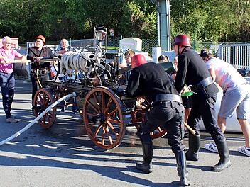 Viel Muskelkraft war nötig, um das Feuer zu löschen. Den historischen Einsatz demonstrierten die Brandschützer mit ihrer noch funktionstüchtigen Handdruckspritze von 1901. Foto: Feuerwehr/Maria Müller