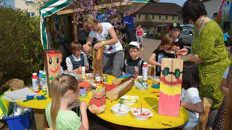 Der Obst-und Gartenbauverein bot den Kindern die kreative Bemalung von Holzscheiten an und dies wurde von den Kids rege und begeistert wahrgenommen. Mit im Bild die Mitglieder und Kinderbetreuer Nicole Szymala (links stehend) und Nadine Scherbel (rechts), die sich liebevoll um die Kids kümmerten. Foto: K.-H. Hofmann