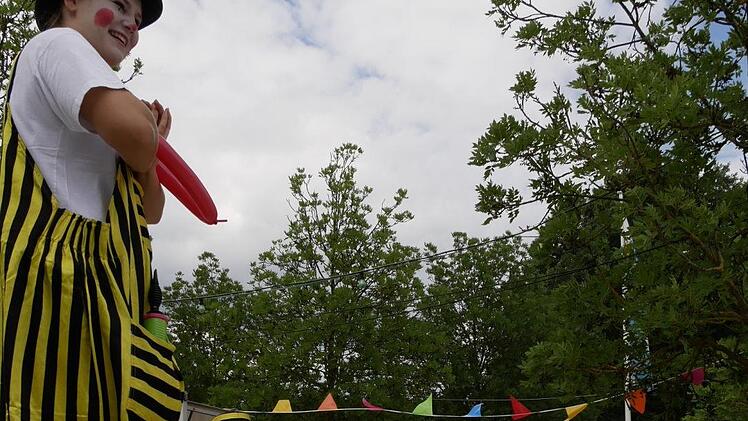 Vorschulkind Yannik (re.) überlegt, ist mutig und fragt den großen  Stelzenclown einfach, was er schon immer wissen wollte: "Warum bist du so groß geworden?" Sehr gute Frage, Yannik! So ein langer Lulatsch fällt ja schließlich auch auf, tanzt aus der Reihe. "Weil ich viel Kartoffelbrei gegessen habe", klärt ihn der Stelzenclown auf. Foto: Manja von Nida