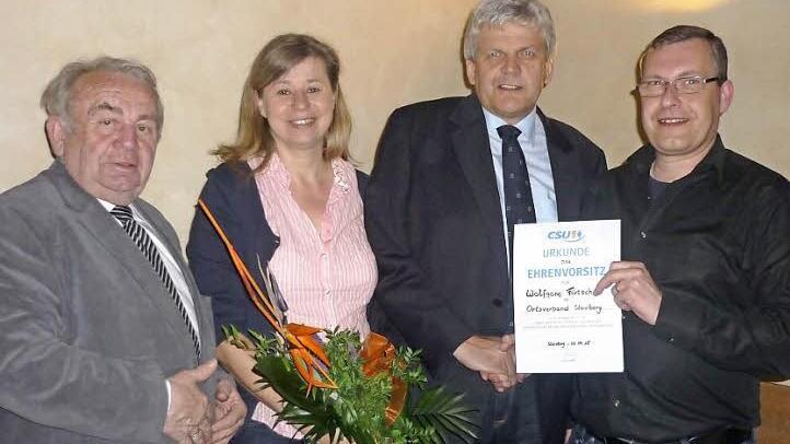 Mit einer Urkunde für den neuen Ehrenvorsitzenden Wolfgang Förtsch und einem Blumengruß für Gattin Bettina bedankten sich der neue CSU-Ortsvorsitzende Jochen Gleich (rechts) und Ehrenkreisvorsitzender MdL a. D. Heinz Hausmann (links) für 24 Jahre Vorstandsarbeit. Foto: Heike Schülein