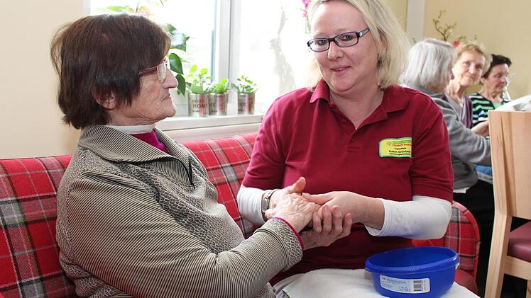Eine Handmassage und ein Pläuschchen mit Brigitte Müller (links): Die Arbeit mit Menschen macht Katrin Grünbeck richtig Spaß.  Foto: Lisa Kieslinger