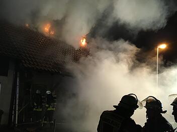 In Machtilshausen im Kreis Bad Kissingen brannte am Montagabend ein Wohnhaus. Zahlreiche Feuerwehrleute kämpften gegen die Flammen an und versuchten ein Übergreifen auf das Nachbargebäude zu verhindern. Foto: Ralf Ruppert