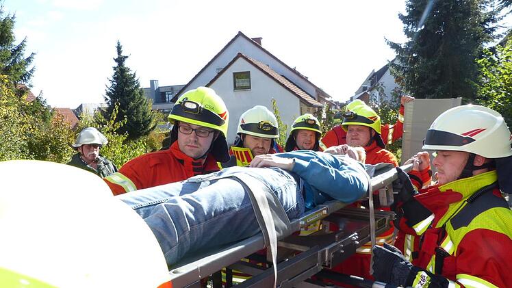 Eine mit dem Rettungskorb der Helmbrechtser Drehleiter   in Sicherheit gebrachte Person wird zur weiteren Behandlung dem BRK übergeben. Foto: Klaus-Peter Wulf