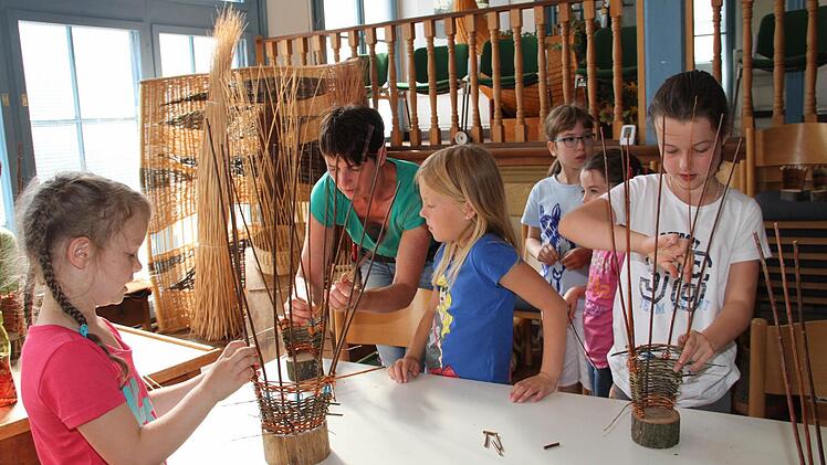 Unter der Anleitung von Flechtwerkgestalterin Gitti Klitzner (Zweite von links) sind die Mädchen eifrig bei der Sache.  Foto: Gerda Völk