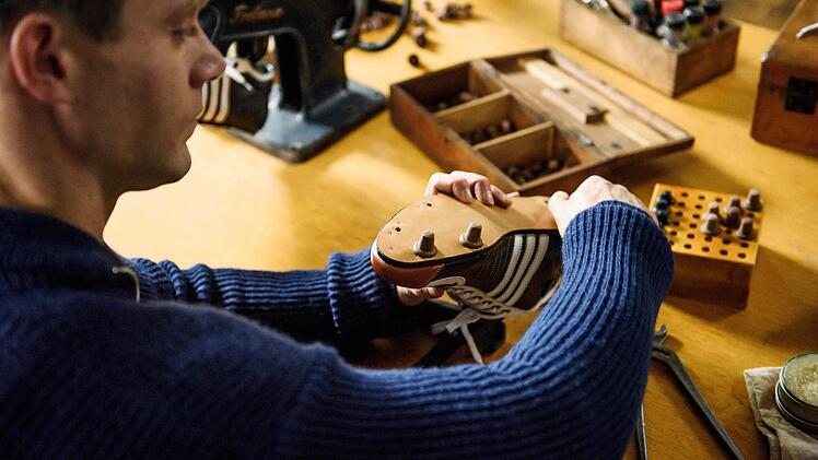 Fußball-Weltmeisterschaft in Bern 1954: In der Kabine der Nationalmannschaft verschraubt Adi Dassler (Ken Duken) die Stollen an die Schuhe der Deutschen Spieler. Foto: RTL/Willi Weber
