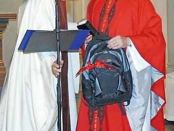 Einen Rucksack hatte Dekan Roland Huth (links) dem neuen Seßlacher Stadtpfarrer, Norbert Lang, zur offiziellen Amtseinführung in der Stadtkirche mitgebracht. Foto: Bettina Knauth