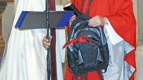 Einen Rucksack hatte Dekan Roland Huth (links) dem neuen Seßlacher Stadtpfarrer, Norbert Lang, zur offiziellen Amtseinführung in der Stadtkirche mitgebracht. Foto: Bettina Knauth