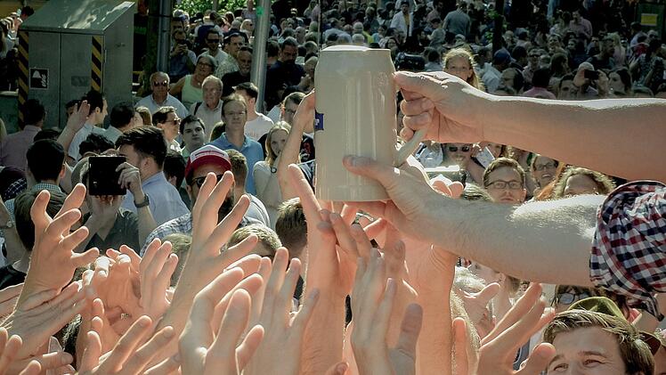 Besucher versuchen am 01.06.2017 in Erlangen (Bayern) beim traditionellen Fassbieranstich der 262. Bergkirchweih einen der ersten Krüge mit Freibier zu ergattern. Bis zum 12. Juni erwartet die Stadt Erlangen mehr als eine Million Besucher auf dem Burgberg. Foto: Thomas Langer/dpa