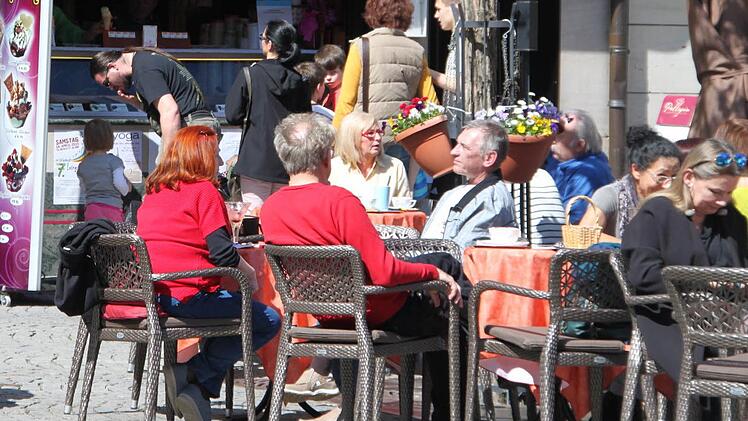 Eisessende und Sonnenanbetende sitzen vor der "San" am Kulmbacher Marktplatz. Früher hießen sie: Eisesser und Sonnenanbeter - Bezeichnungen, die aber so gar nicht geschlechtergerechet sind. Verbaler Sexismus halt. Foto: Julian Seiferth