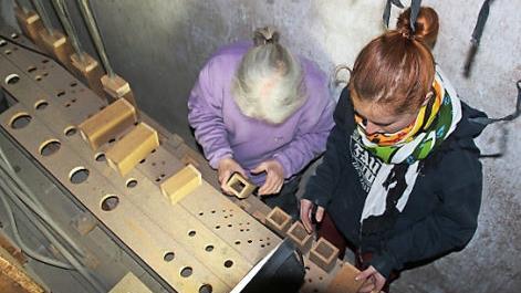 Die Orgelbauerinnen Monika Sommer und Lea Graumann beim Einbau der historischen Windläden der Seuffert- Orgel in Banz.