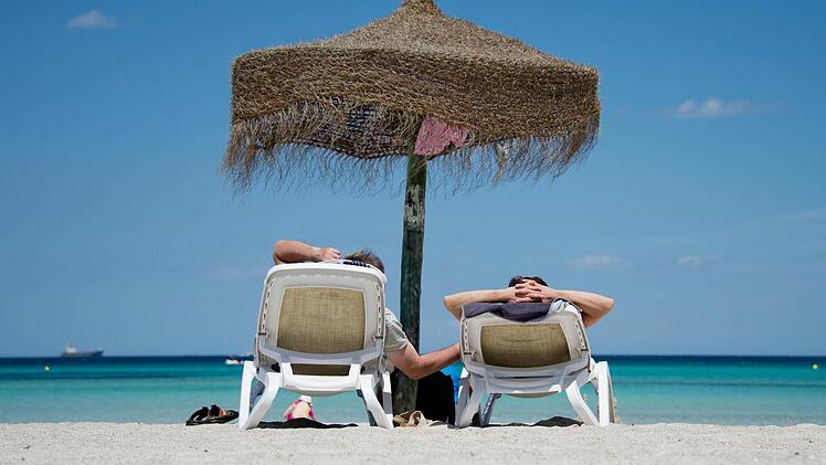 Deutsche Urlauber am Strand an der Platja de Muro im Norden Mallorcas (Spanien) - eines der beliebtesten Reiseziele. Foto: Julian Stratenschulte/dpa