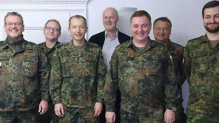 Oberstleutnant d.R. Frank Greif (3.v.r.) und sein Stellvertreter Major d.R. Matthias Walz (3.v.l.) zusammen mit H&ouml;chstadts B&uuml;rgermeister Gerald Brehm (Bildmitte in Zivil) und einigen Angeh&ouml;-rigen des KVK Erlangen-H&ouml;chstadt bei dessen Besuch im H&ouml;chstadter Rathaus. Foto: privat