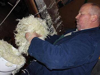 Jürgen Krafft füllt für einen Kunden einen Eimer voller Sauerkraut.  Fotos: Sabine Herteux