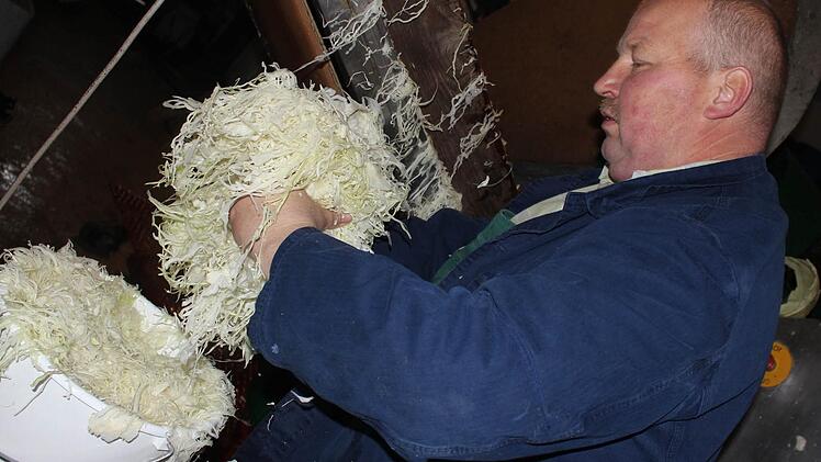 Jürgen Krafft füllt für einen Kunden einen Eimer voller Sauerkraut.  Fotos: Sabine Herteux