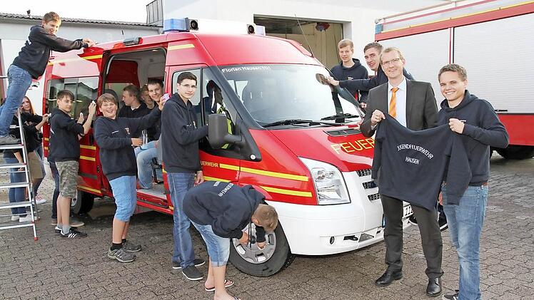 Das neue Mehrzweckfahrzeug wird von der engagierten Jugendfeuerwehr auf Hochglanz gebracht. Dafür gab es einheitliche Kapuzenpullover von der Volksbank. Geschäftsstellenleiter Thorsten Erlwein (Zweiter von rechts) hat sie an Jugendleiter Timo Sokol übergeben.  Foto: Mathias Erlwein