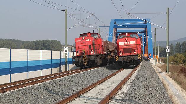 Zwei von Dieselloks gezogene Güterzüge mit jeweils 1200 Tonnen Gewicht fahren gemeinsam über die Mainbrücke. Foto: Matthias Einwag